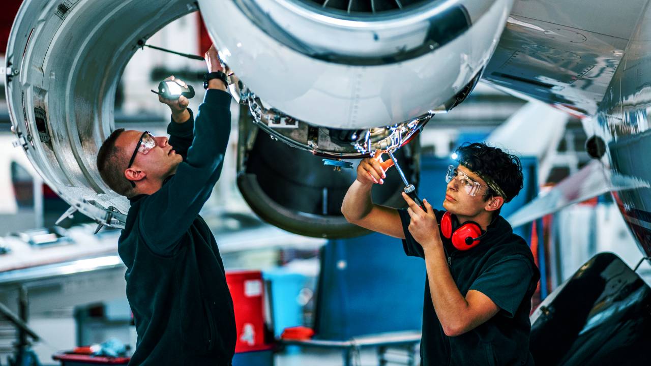 Man in safety goggles looking at piston head of machine